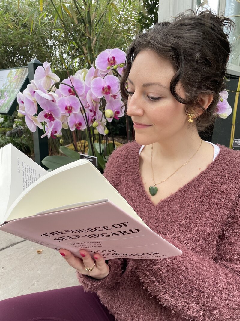 A wellness coach stands in a lush botanical garden, looking up and smiling at the beautiful big blooming white and purple orchids. The bright colors and natural beauty of the orchids create a sense of peace and tranquility. The image evokes feelings of relaxation, self-care, and mindfulness, making it perfect for anyone interested in wellness and personal growth. The wellness coach's smiling face and posture suggest positivity and encouragement, inviting viewers to join her in her practice. [Nicole QW]