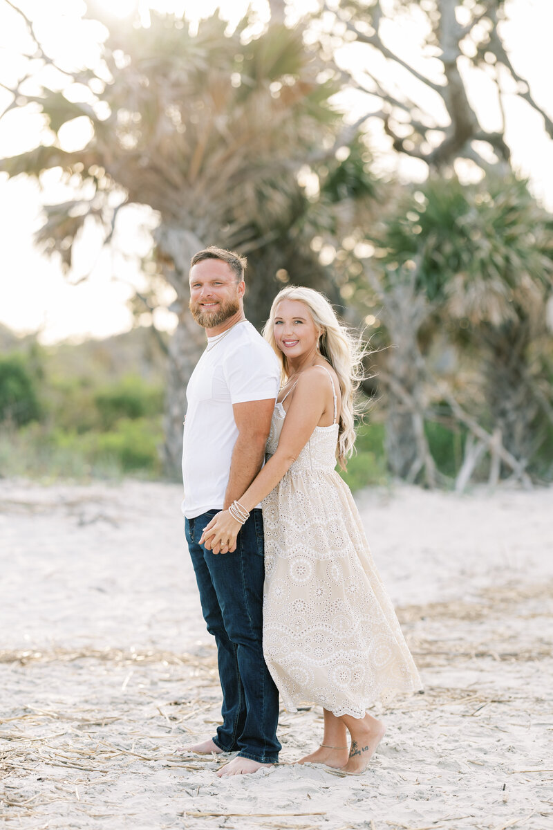 engaged couple embracing on the beach