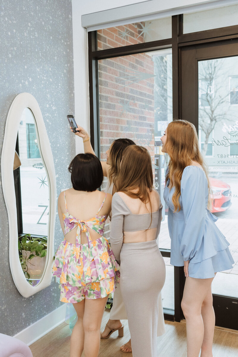 Three women taking a selfie of new lash extensions at Luna Lash studio
