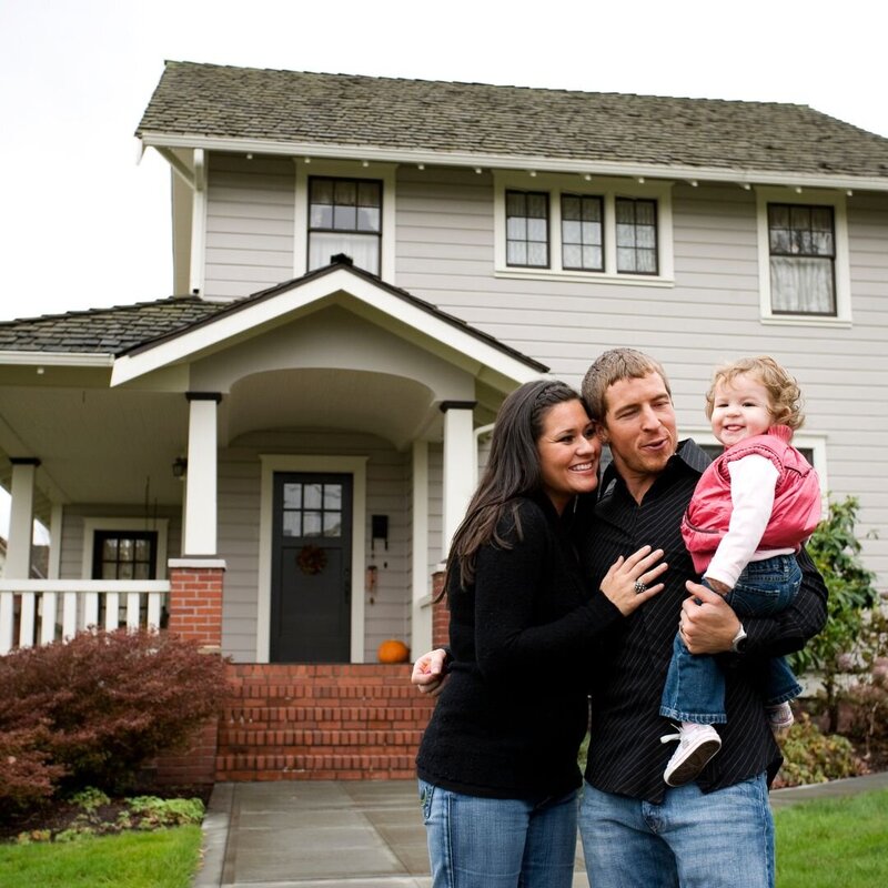 Happy family in front of their newly purchased home in Southern New Hampshire, symbolizing the successful home-buying experience facilitated by Lauryn DeNenno