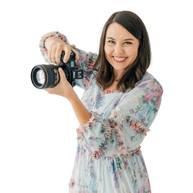 katiera the wedding photography education mastermind educator is smiling at the camera while holding her camera