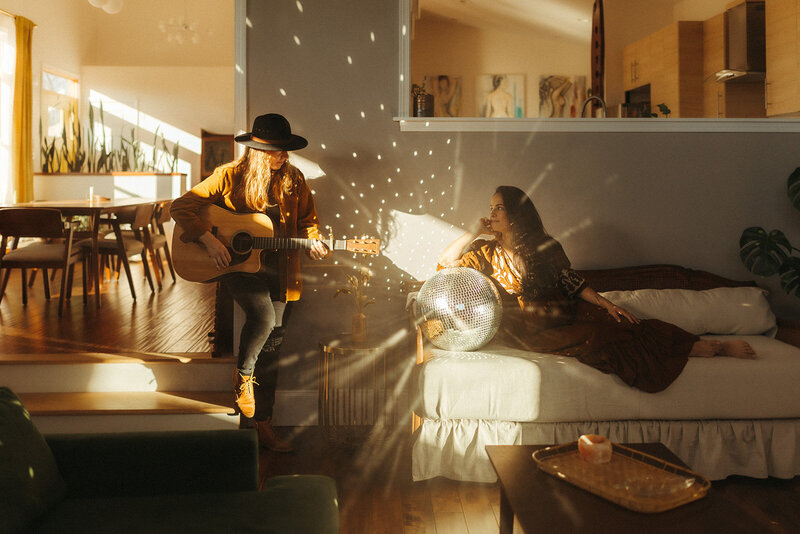 couple sitting in the living room while playing guitar