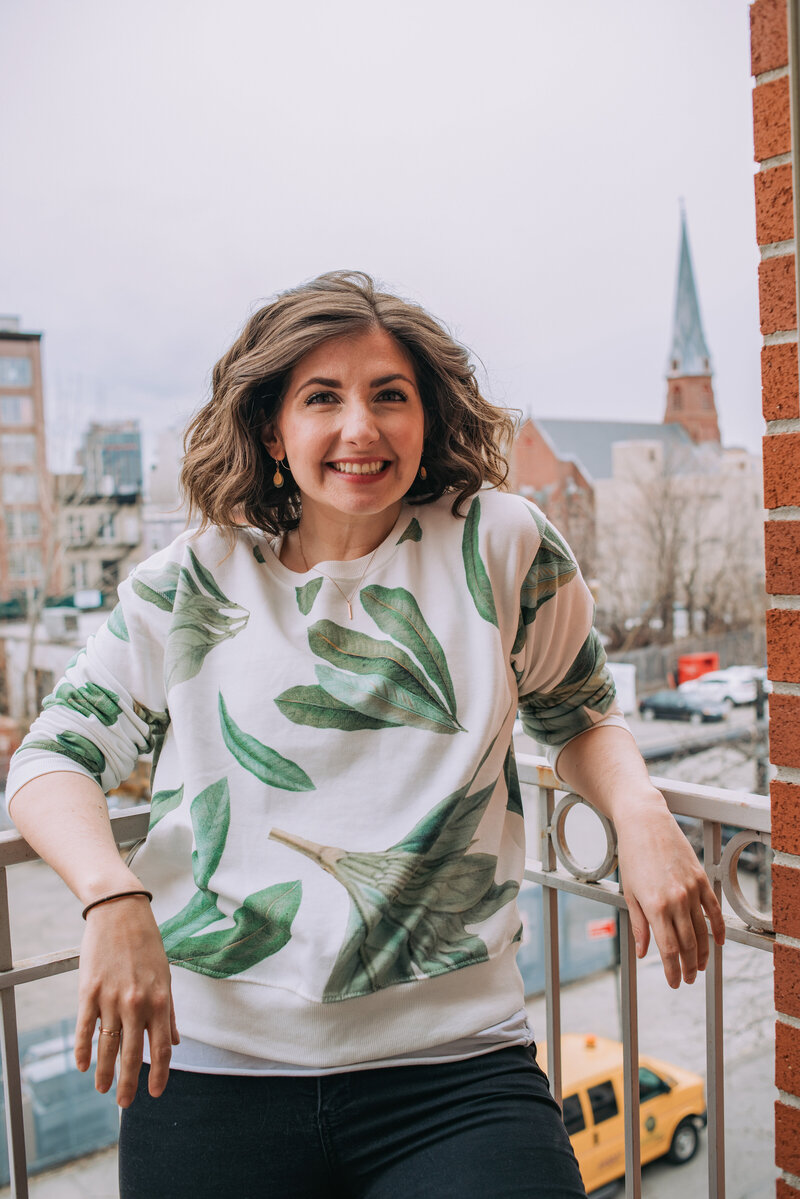 Maria stands on her small apartment balcony in NY