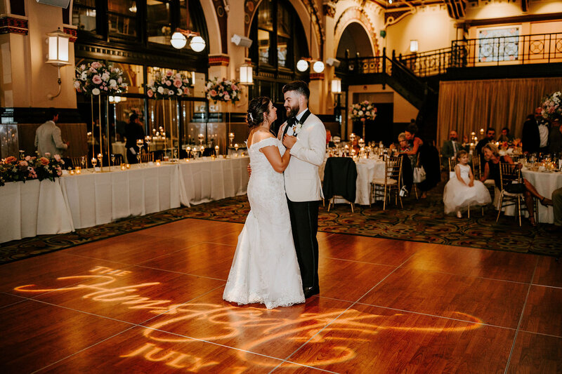 bride and groom kissing at a table decorated with peach flowers