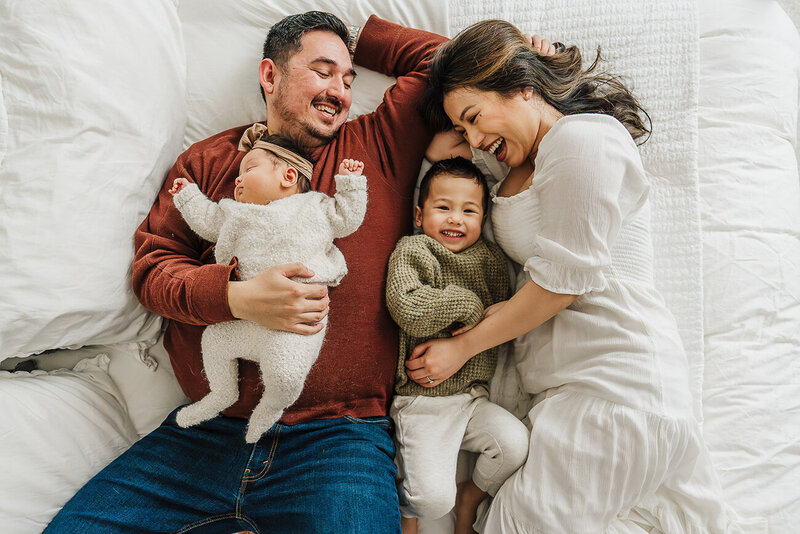 family snuggles together with dog in new baby nursery during boston newborn photos