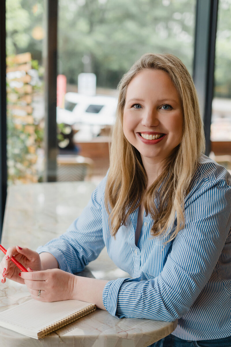 Headshot of copywriter Anna Bradshaw in a blue striped shirt