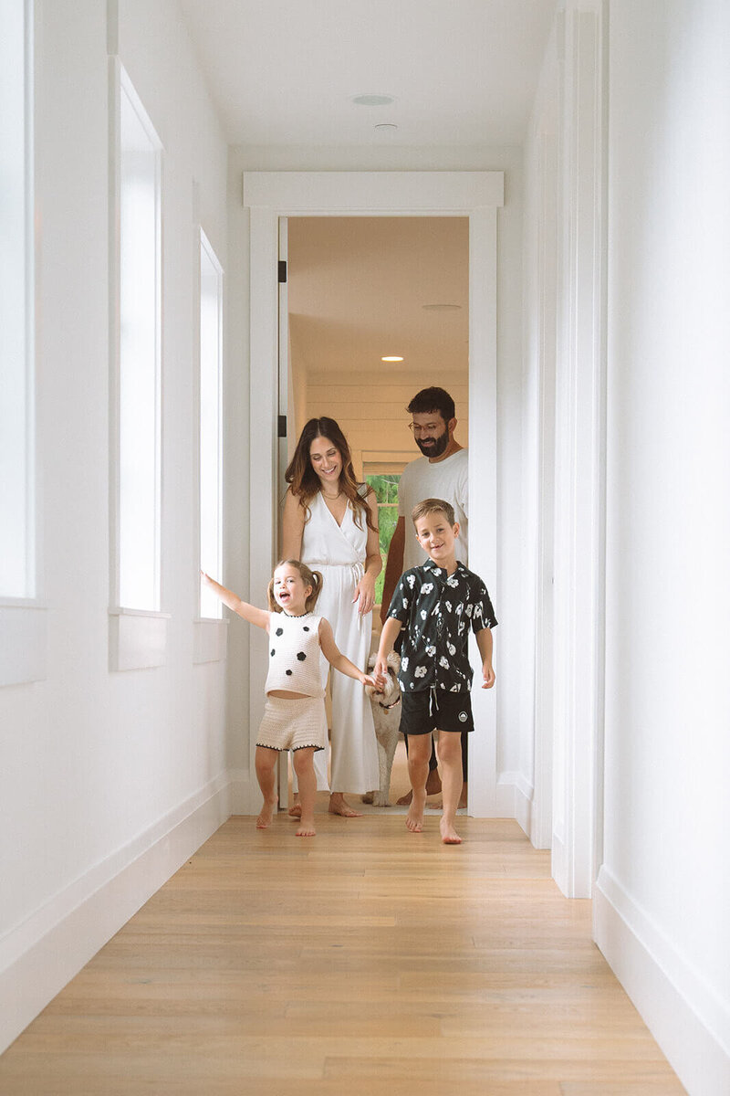 family of four at home with kids in upstairs hallway irvine