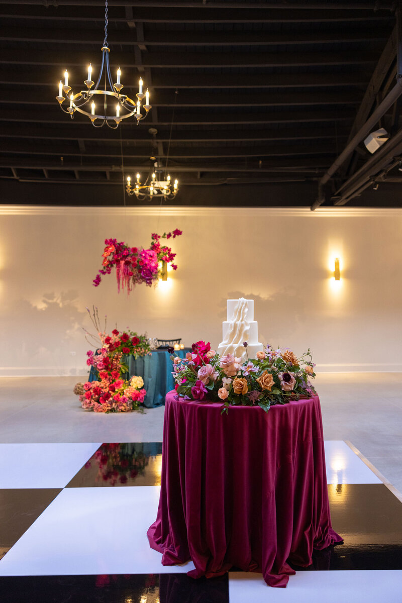 black and white tiled dance floor at Chicago venue for luxury wedding, bold jewel tone florals and linens