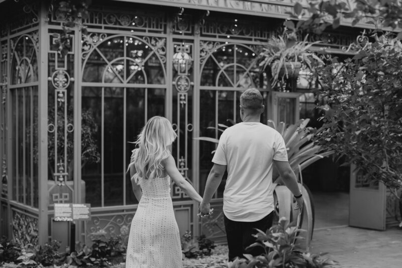 Couple walking to Woodlands Mosaic at Denver Botanic Gardens during engagement photos