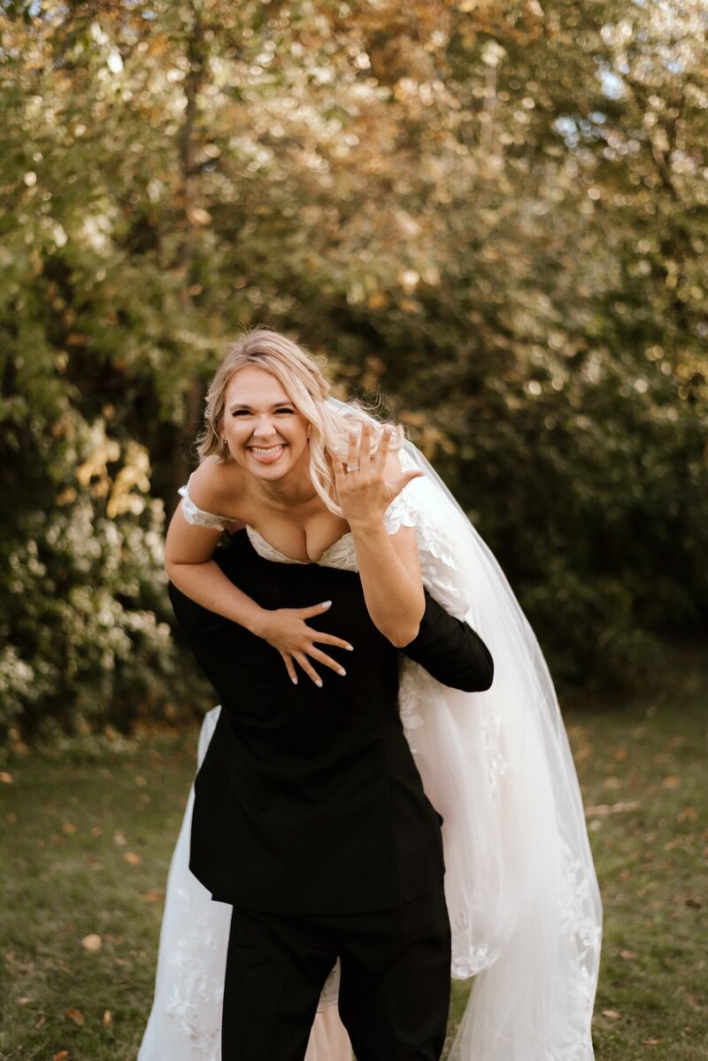 groom carries bride on wedding day in peoria il