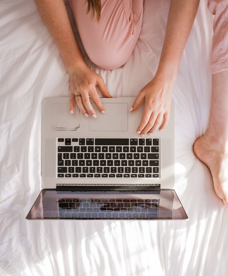 social media management suggestion shot from above of a girl on a laptop in bed