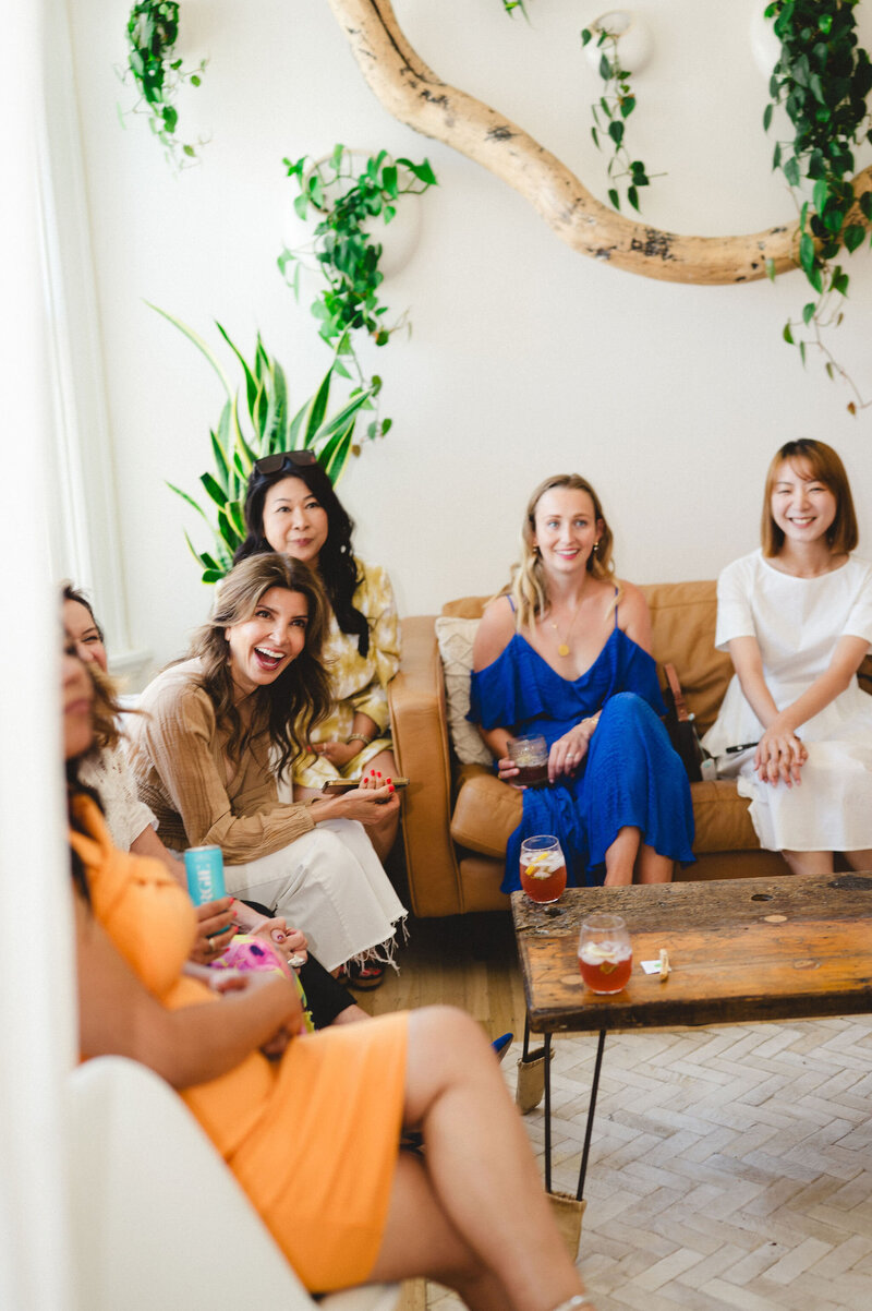 Cassandra sitting on stage with beauty founder, talking