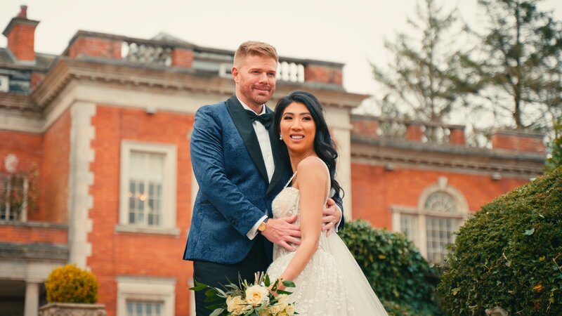 Bride and groom stood on the steps outside  the beautiful Eaves Hall  Clitheroe takne by wedding  videographer Anthony Horseman