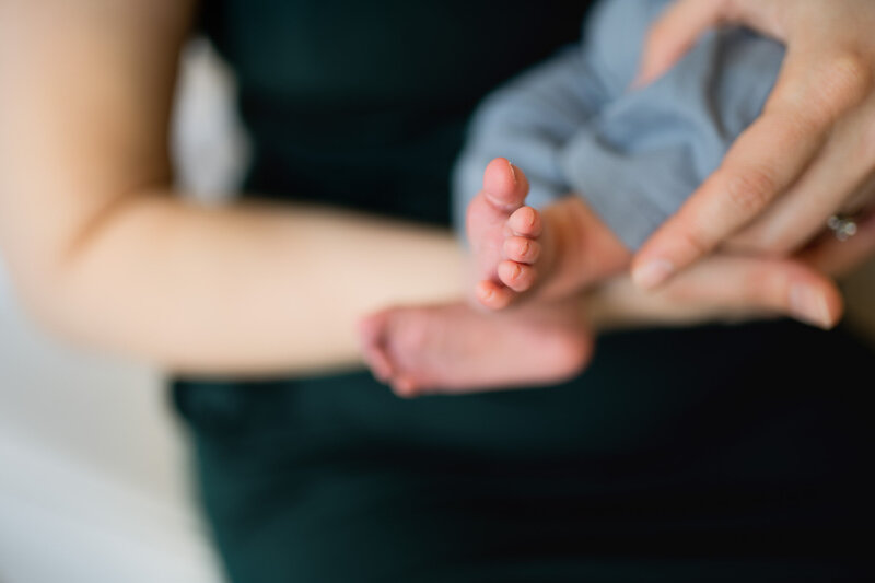 mom holding newborn baby and smiling and strongsville