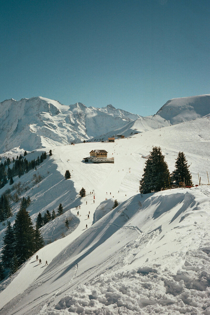 Snowy mountain with a yellow building in the distance