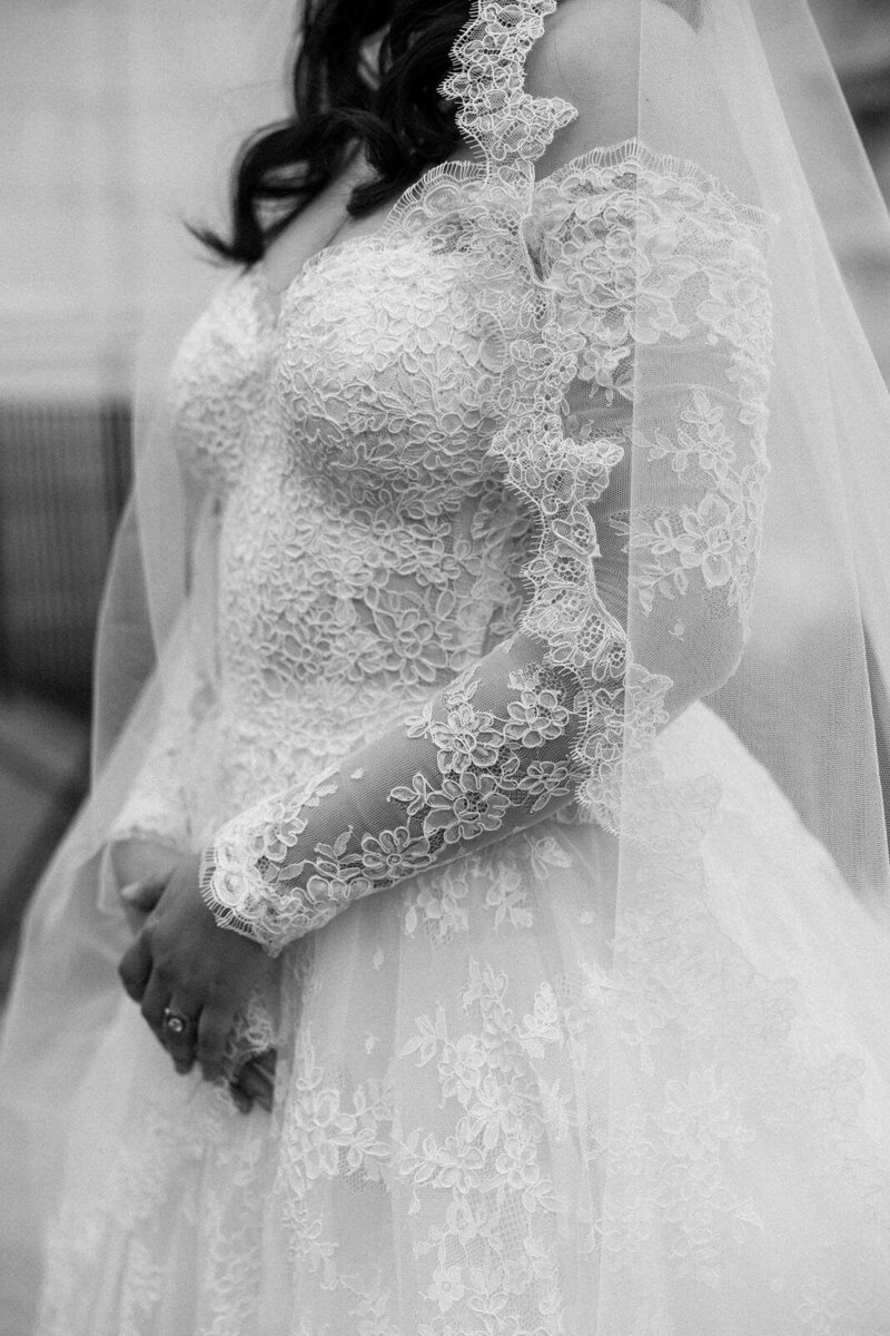 Detail photo of a bride's lace wedding day gown at Rosecliff Mansion in Rhode Island, captured by Andrea-Marie Photography