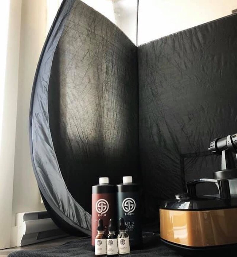 Spray tan booth next to spray tan machine