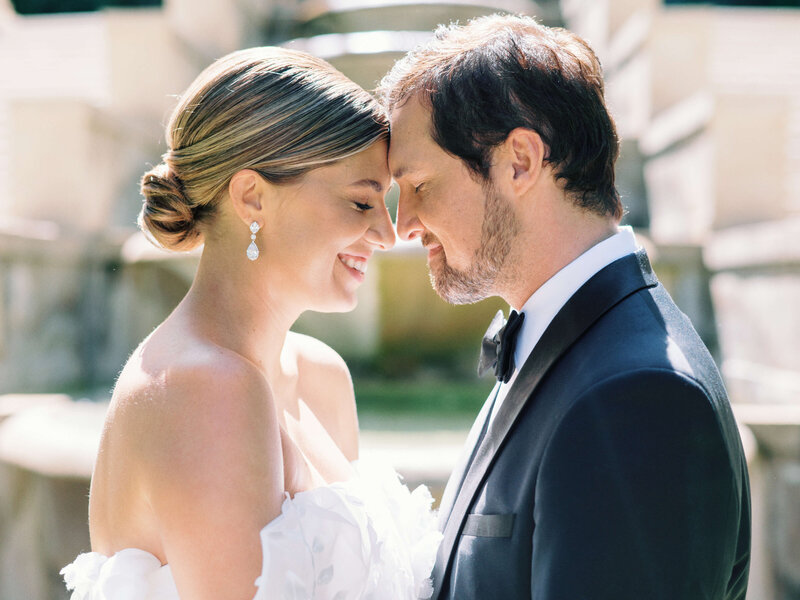 Stylishly dressed groom and his bride stand with their foreheads together in an image taken by DMV wedding photographer Erin Winter Photography