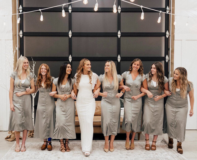 A bride and her grey-dressed bridesmaids posing for a photo.