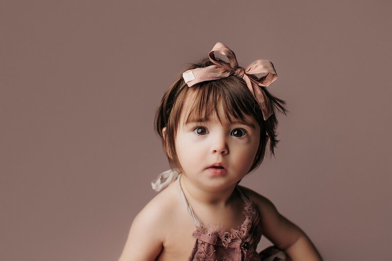 Joyful baby captured mid-laugh in natural light studio