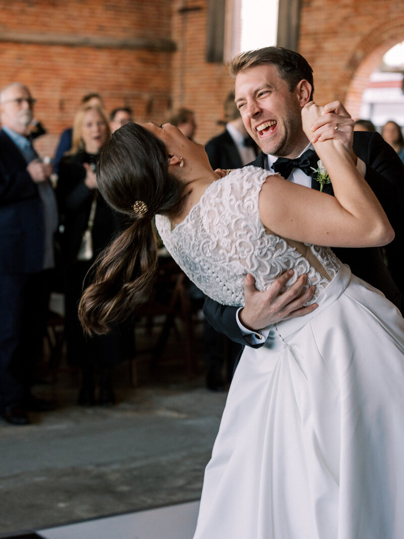 Bride and groom have their first dance with huge smiles on their faces