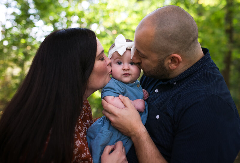 Family photographer capturing a mom, dad and two young children outside.