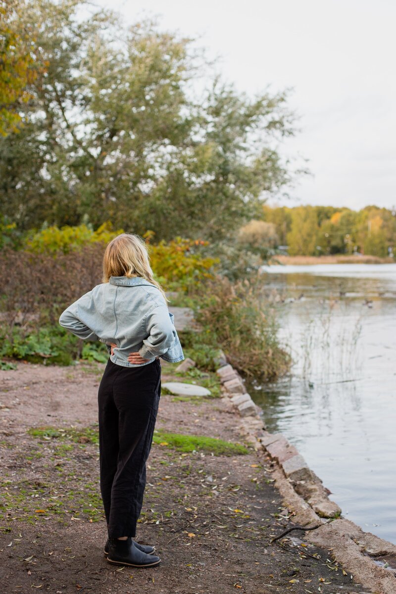 mielen paremminvoinnin ja kehomieliyhteyden valmentaja seisoo rannalla ja katsoo järvelle päin