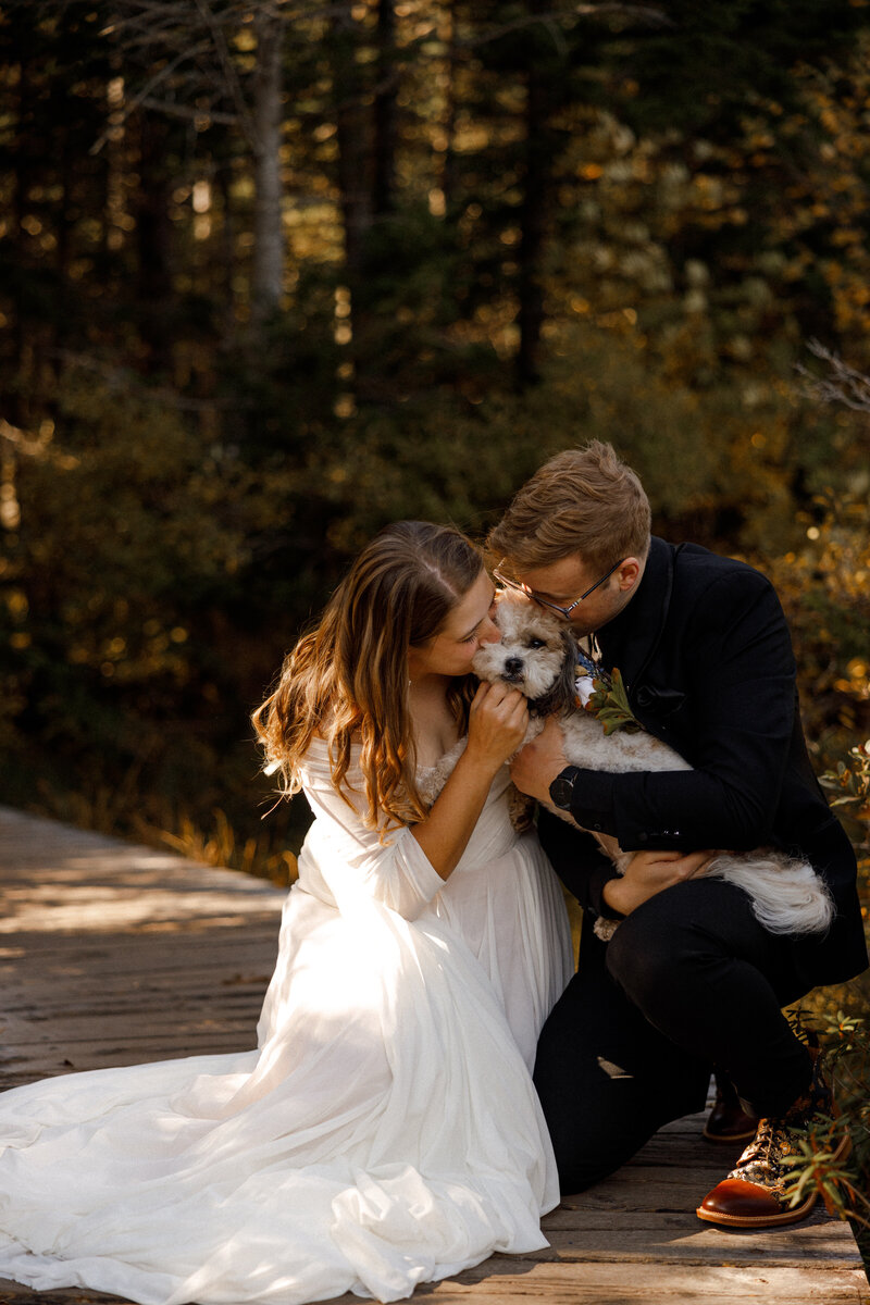 Couple kissing their dog before saying their vows to each other in New Hampshire 