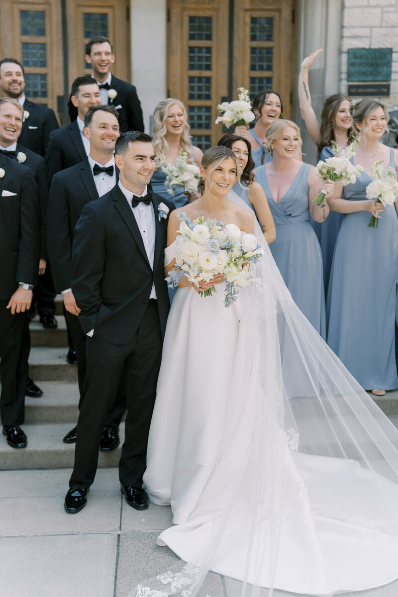 wedding couple with wedding party outside on venue steps