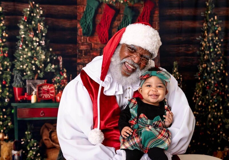 Black Santa hugging young girl smiling