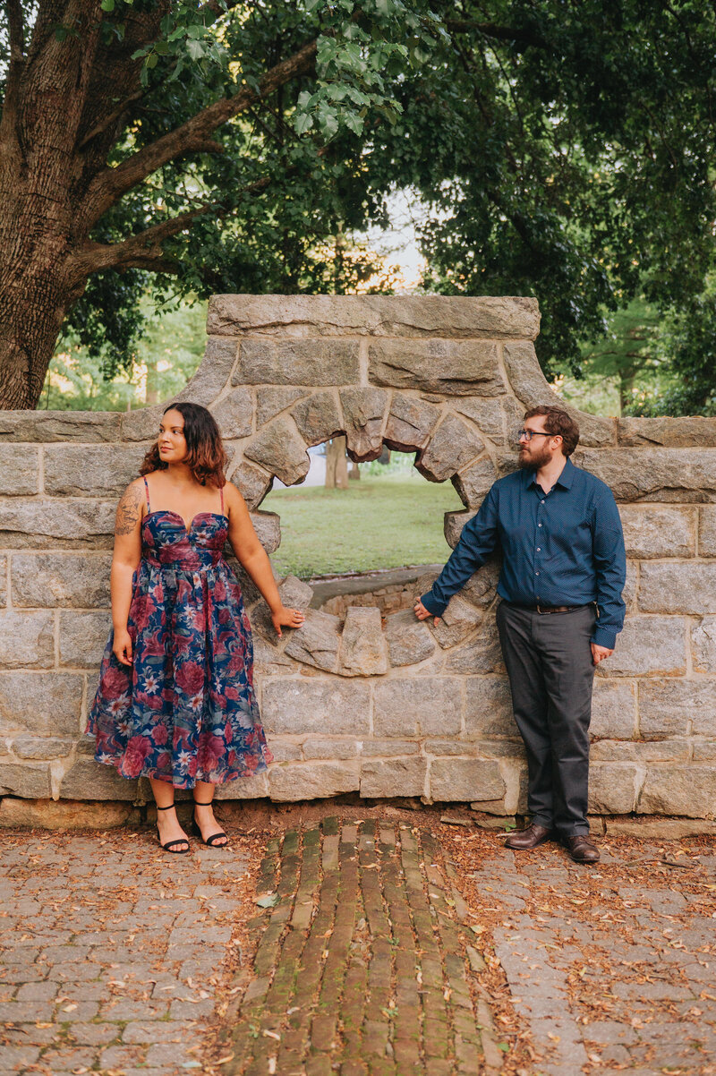 A couple holds a stone wall