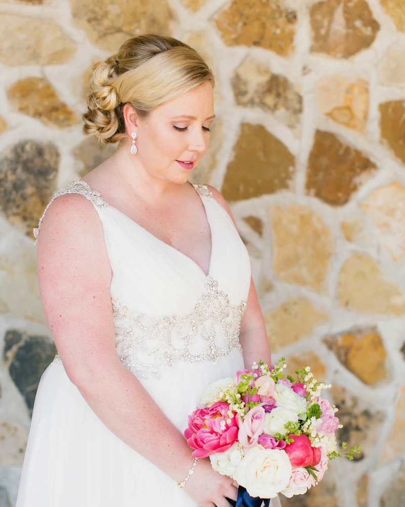 Bride holds bouquet as she looks down
