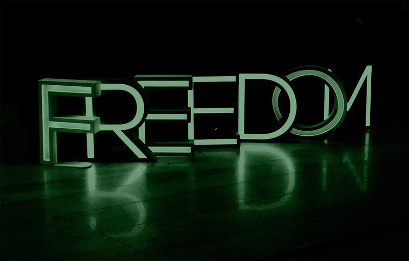 Freedom letters on a dark background to representing getting out of debt with a web design side hustle