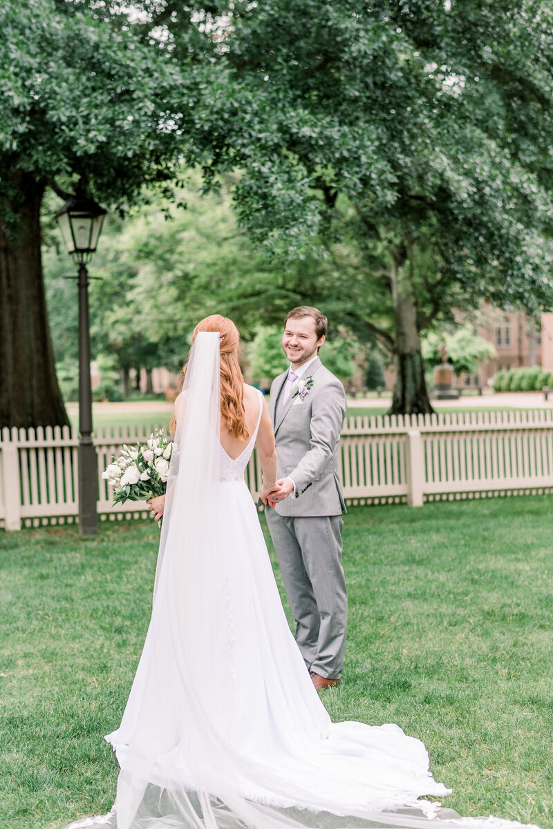 Bride and groom portrait outside on the campus of William & Mary, surrounded by lush greenery and trees, captured after their wedding ceremony and coordinated by Sweet Caroline Events