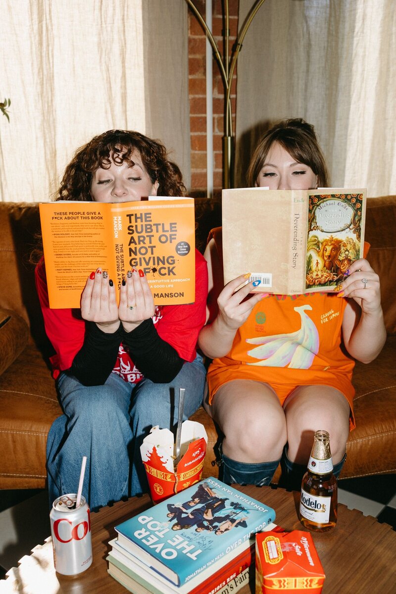 A woman sitting on a curb sticking her tongue up.