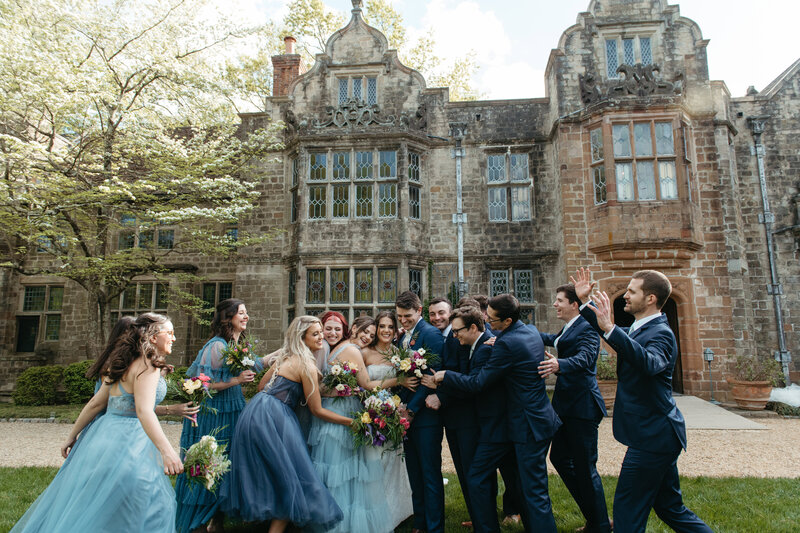 Bride and groom surrounded by bridesmaids and groomsmen outside the Virginia House