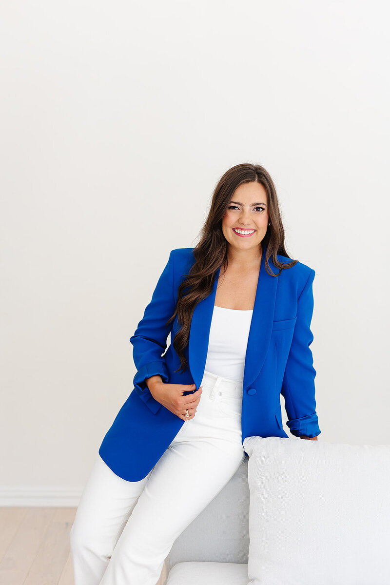 Abby Manawes posing in a white outfit and blue blazer