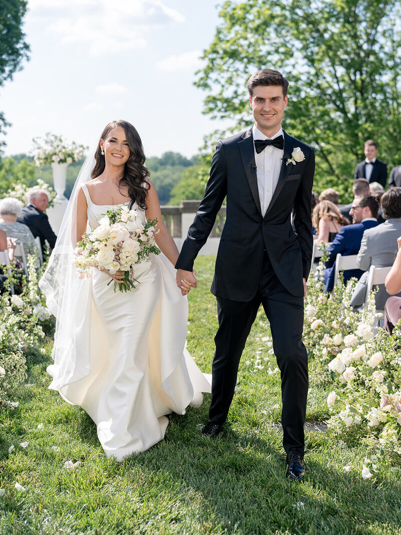 bride and groom hold hands at their wedding ceremony