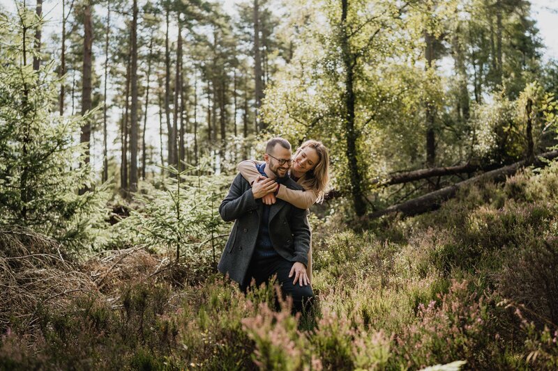 A couple walk hand in hand for engagement photos at Dunnottar Castle.