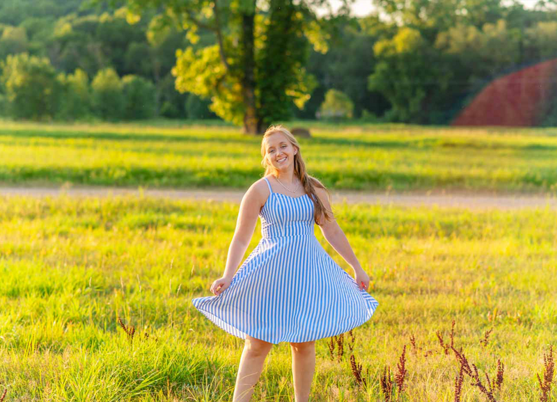 high school senior girl twirling in field at ionia fair grounds
