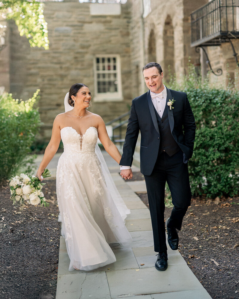 Bride and groom sit on a green couch for a portrait at their Elkins Estate Wedding.