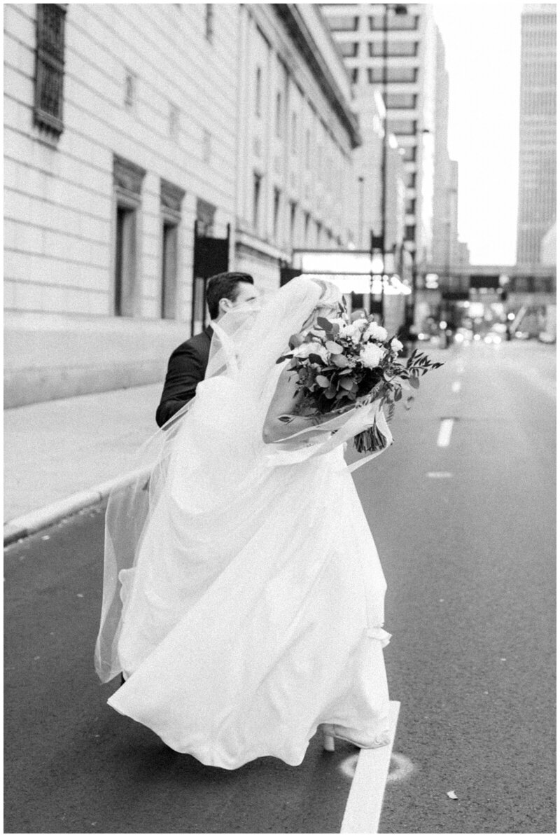 Black and white photo of couple crossing the street on their wedding day downtown Cincinnati