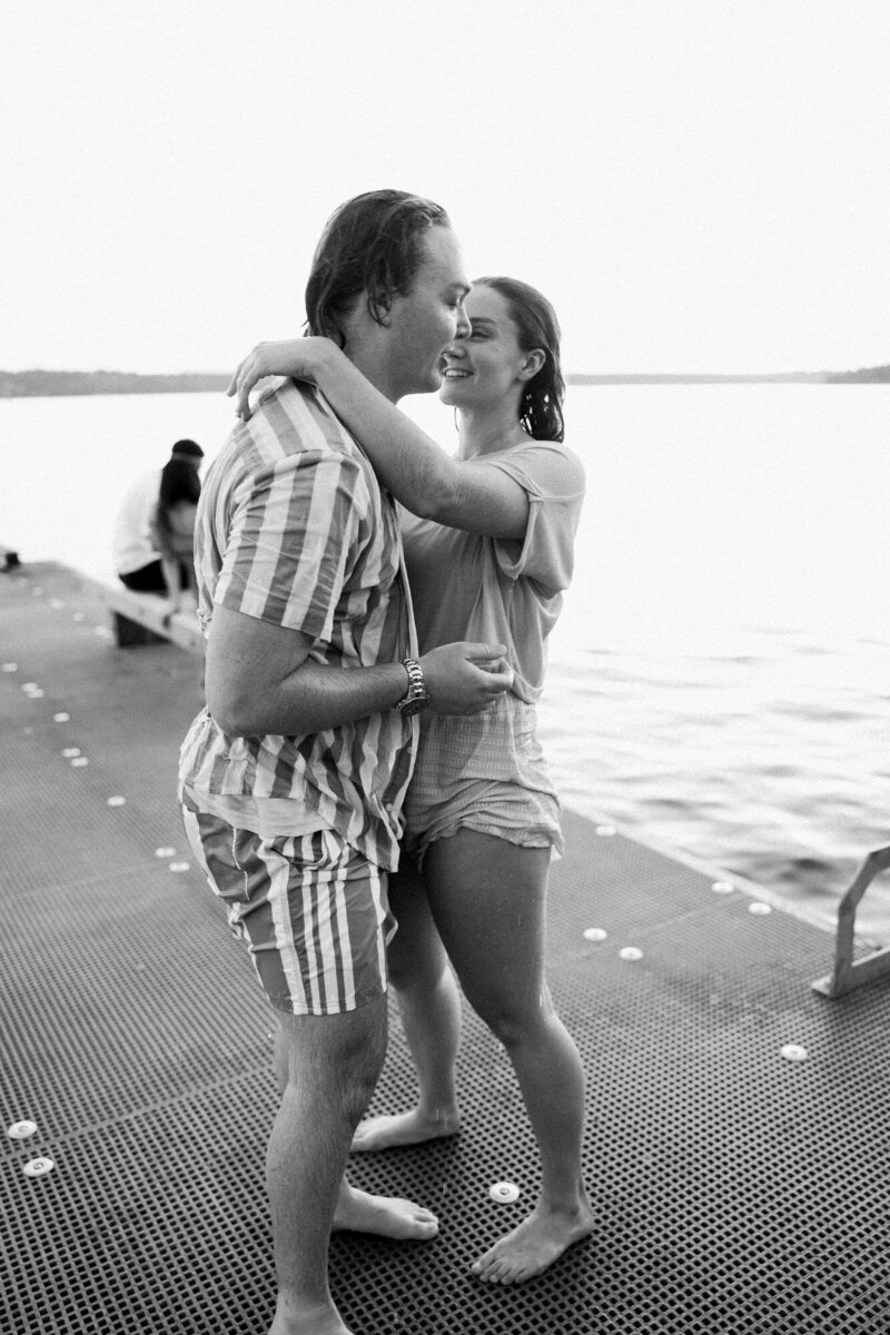 a couple kiss after they are wet from jumping off the dock.