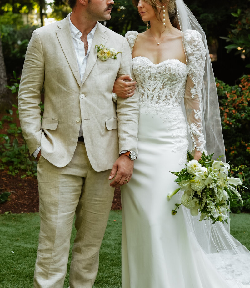 Bride and Groom staring at each other longingly. Bride has sleeves with white bouquet. Wedding in Seattle