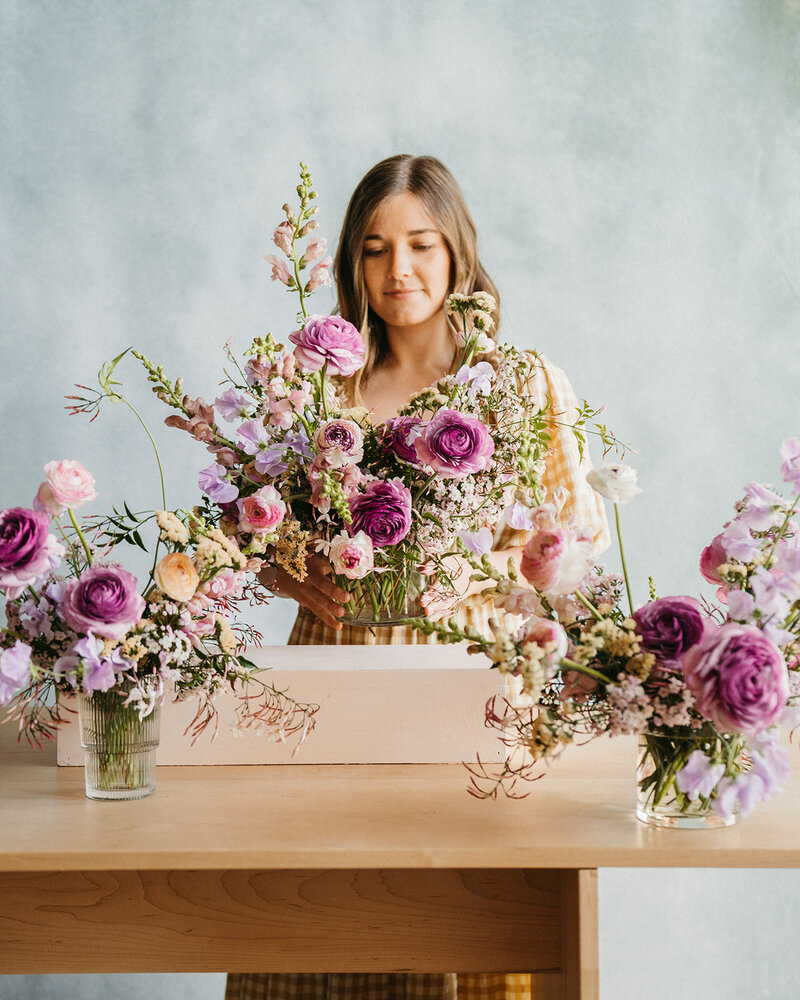 Florist creating purple flower arrangements