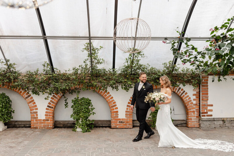 Bride and groom walking in Madison Greenhouse wedding venue