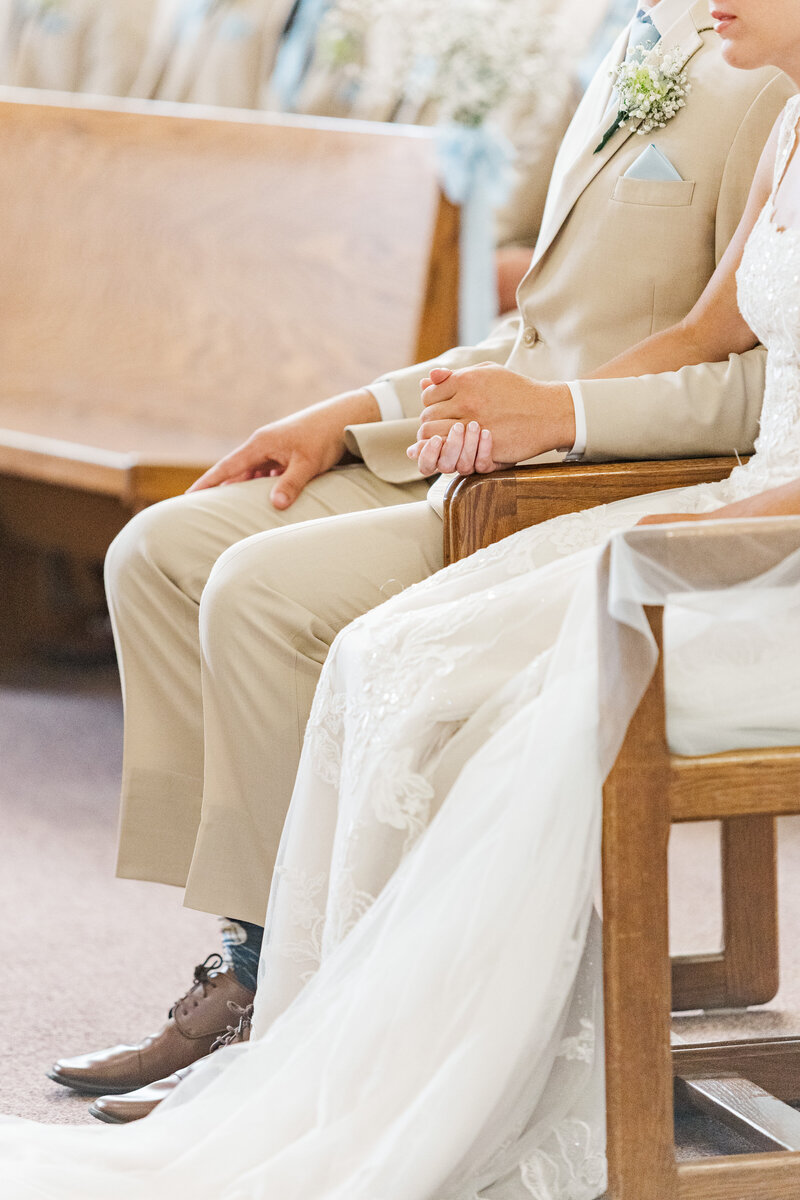 close up of bride and groom holding hands during their wedding ceremony