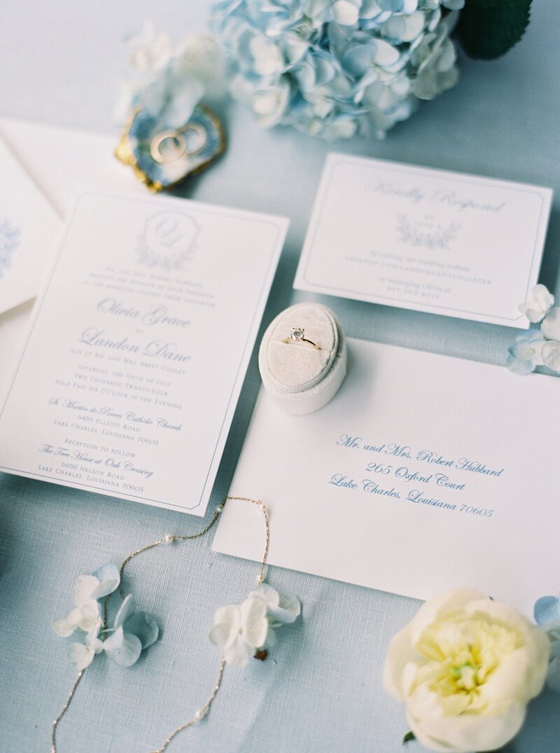 Flatlay of a wedding invitation suite styled with elegant details, captured by Morgan Alysse, fine art wedding photographer in Lafayette.