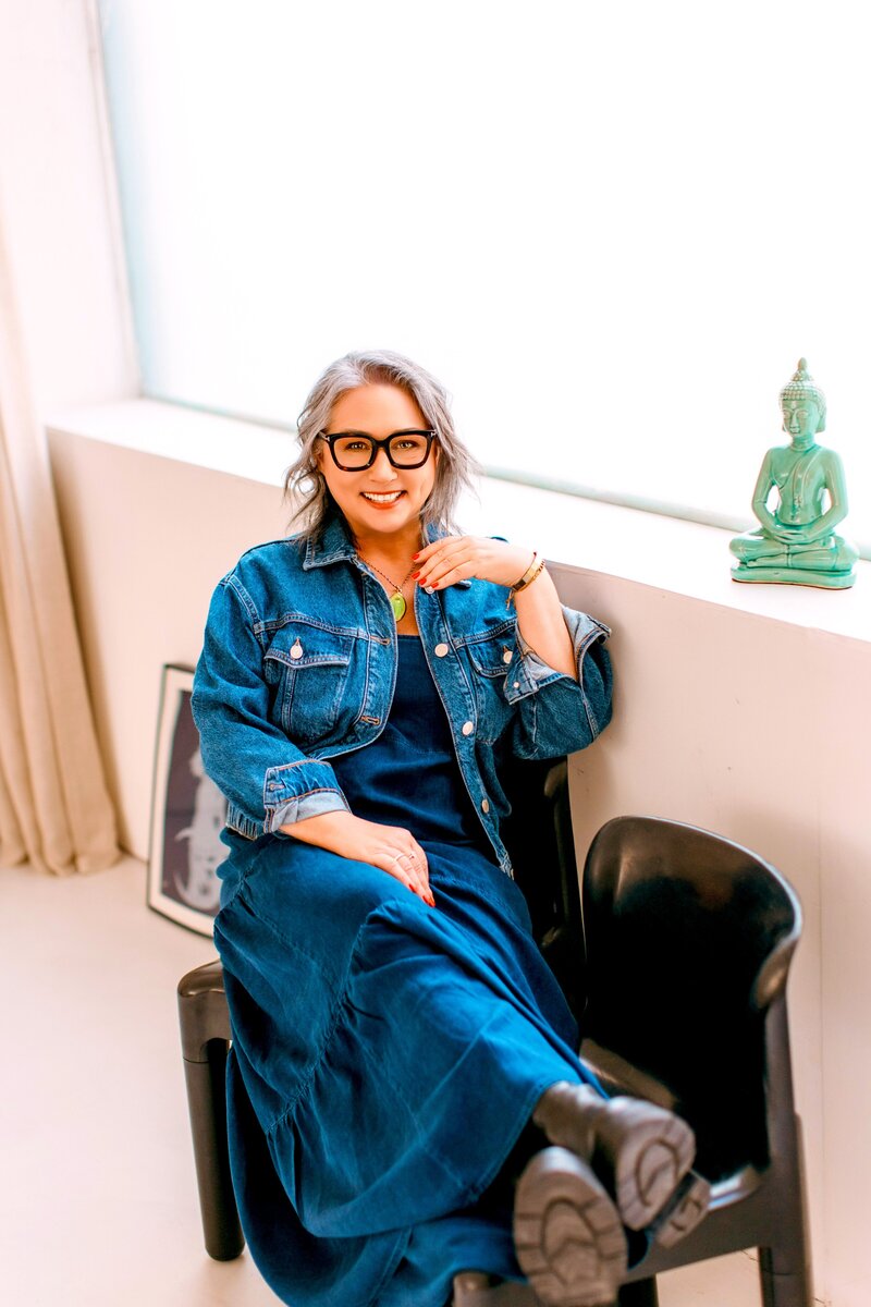 Astrocartographer Kristine Odegard sitting in a black chair with a green buddha next to her