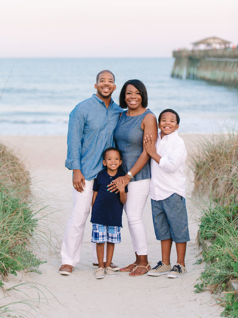 Premium Photo | A family poses for a photo by the fire at the beach.